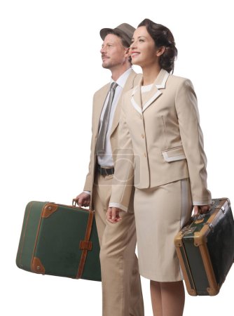 Téléchargez les photos : Élégant couple vintage marchant et tenant des valises, concept de voyage - en image libre de droit