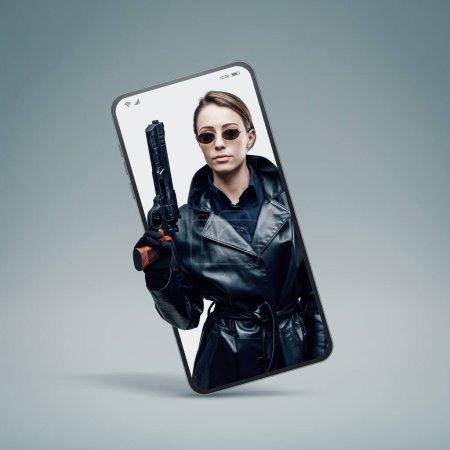 Foto de Agente espía femenino fresco en abrigo de cuero negro en un videocall para teléfonos inteligentes - Imagen libre de derechos