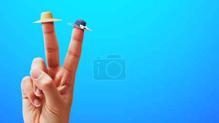 Téléchargez les photos : Main féminine faisant un signe V et portant de minuscules chapeaux de plage sur deux doigts, concept de vacances d'été - en image libre de droit