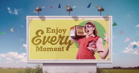 Photo for Happy lazy housewife having fun and inspirational quote on billboard advertisement: enjoy every moment - Royalty Free Image
