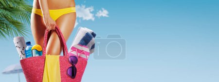Téléchargez les photos : Belle femme en forme tenant un sac avec des accessoires et allant à la plage, concept de pause d'été, espace de copie - en image libre de droit