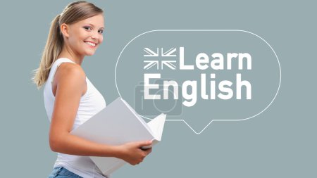 Photo for Young smiling woman holding a book and learning English, school and education concept - Royalty Free Image