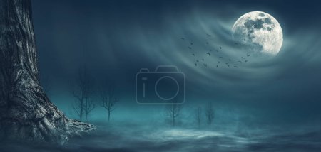 Photo for Scary night scene with trees lit by the full moon in the sky: horror and fantasy background - Royalty Free Image