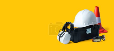 Photo for Construction worker tools and safety equipment: toolbox, hard hat, ear muffs, traffic cone and goggles - Royalty Free Image