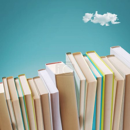 Téléchargez les photos : De nombreux livres disposés en ligne et ciel en arrière-plan, la créativité et le concept d'apprentissage - en image libre de droit