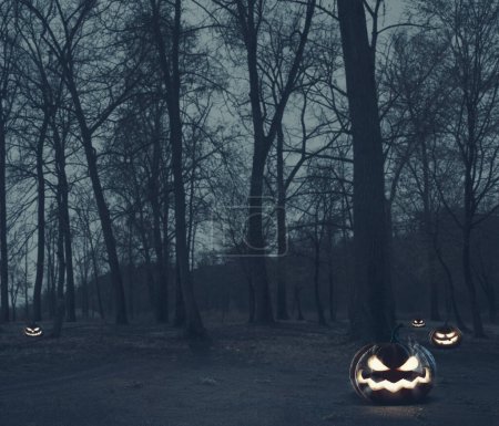 Photo for Spooky Halloween pumpkins in the dark forest at night, horror and mystery background - Royalty Free Image