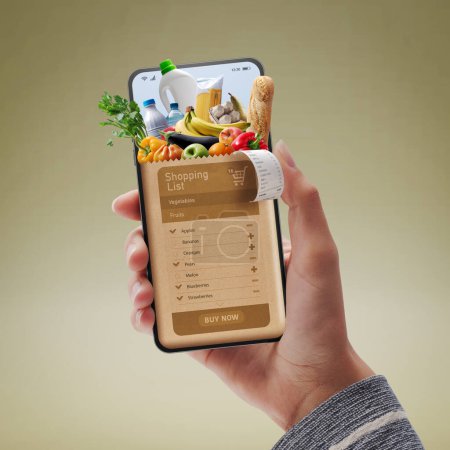 Téléchargez les photos : Online grocery shopping app: customer holding a smartphone and ordering groceries online - en image libre de droit