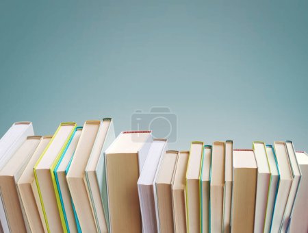 Téléchargez les photos : De nombreux livres disposés en ligne et en espace de copie vierge, concept de lecture et d'apprentissage - en image libre de droit