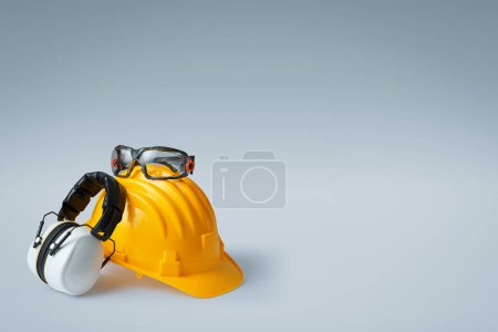 Téléchargez les photos : Casque de sécurité, cache-oreilles et lunettes : équipement de protection individuelle et concept de sécurité au travail - en image libre de droit