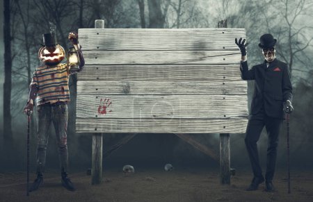 Photo for Spooky horror Halloween characters showing an old blank wooden sign - Royalty Free Image
