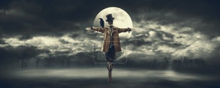 Foto de Espantapájaros espeluznante con cuervo en el hombro y luna llena en el cielo nocturno, horror y concepto de Halloween - Imagen libre de derechos