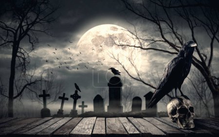 Téléchargez les photos : Ancien cimetière effrayant la nuit avec corbeau effrayant debout sur un crâne humain, pleine lune en arrière-plan : concept d'horreur et d'Halloween - en image libre de droit