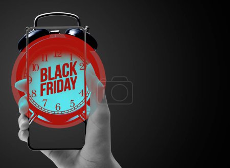 Téléchargez les photos : Main tenant un smartphone et réveil : achats en ligne et concept de vente Black Friday - en image libre de droit