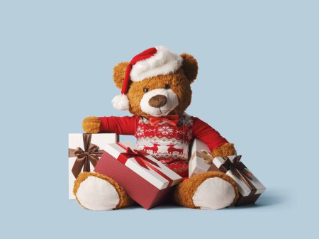 Téléchargez les photos : Mignon ours en peluche portant un chapeau de Père Noël et cadeaux de Noël, vacances et célébrations concept - en image libre de droit
