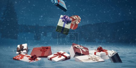 Téléchargez les photos : De nombreux cadeaux de Noël tombant du ciel sur la neige, les vacances et les célébrations concept - en image libre de droit