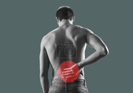 Photo for Young man having a back pain, he is touching his lower back - Royalty Free Image