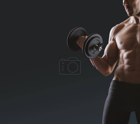 Foto de Hombre guapo sin camisa en forma de pie y haciendo ejercicio, él está levantando una barra - Imagen libre de derechos