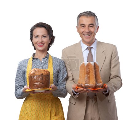 Téléchargez les photos : Couple vintage souriant avec panettone gâteau italien traditionnel et pandoro - en image libre de droit