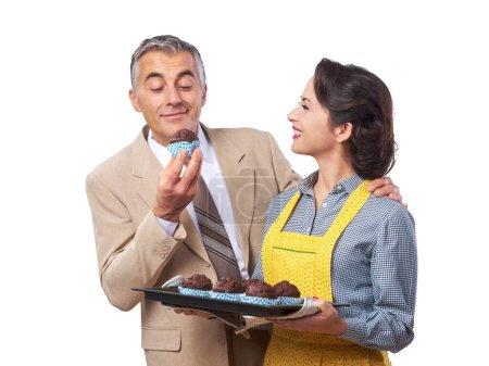 Téléchargez les photos : Vintage femme dans tablier cuisine muffins au chocolat pour son mari - en image libre de droit