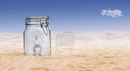 Téléchargez les photos : Homme souffrant de chaleur et de transpiration, il est piégé dans un bocal en verre dans le désert - en image libre de droit