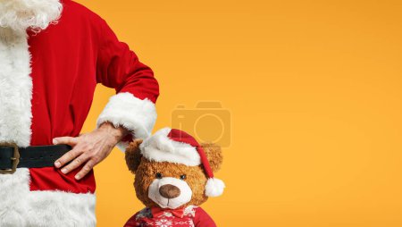 Foto de Santa Claus y lindo osito de peluche posando juntos, Navidad y celebraciones concepto, espacio de copia - Imagen libre de derechos