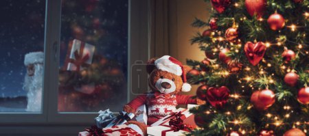 Lindo oso de peluche en casa esperando a Santa Claus en Nochebuena, vacaciones y celebraciones concepto
