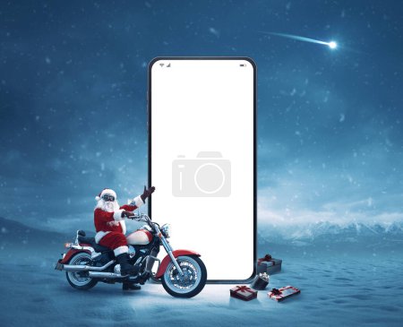 Foto de Motociclista no convencional de Santa Claus y gran smartphone con pantalla en blanco, Navidad y concepto de tecnología - Imagen libre de derechos