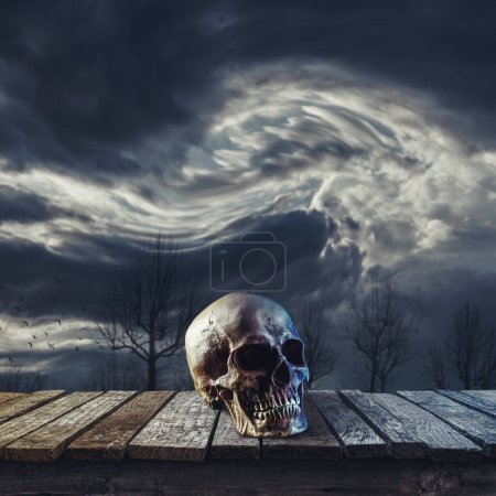 Téléchargez les photos : Crâne humain effrayant sur une terrasse en bois et ciel nocturne nuageux, concept d'horreur et de mystère - en image libre de droit