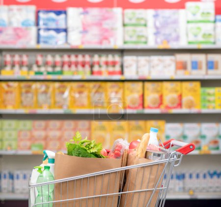 Foto de Interior de la tienda de comestibles con carrito de la compra y estantes de la tienda, concepto de compras de comestibles - Imagen libre de derechos