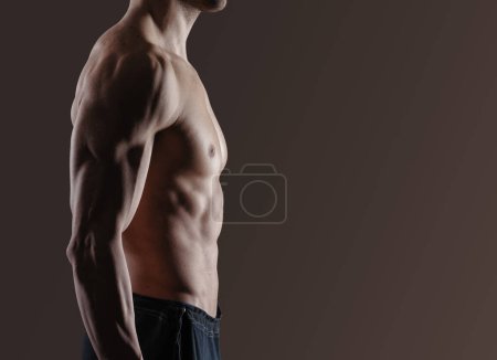 Photo for Fit man posing and showing off his muscles, profile view - Royalty Free Image
