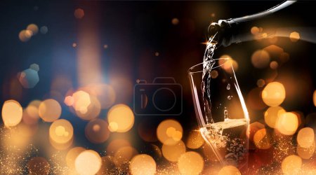 Téléchargez les photos : Bannière de célébration bonne année avec lumière bokeh dorée et vin mousseux versant dans un verre, espace de copie - en image libre de droit