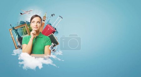 Téléchargez les photos : Femme heureuse rêvant de voyager, elle est entourée d'objets de voyage et de penser main sur menton - en image libre de droit