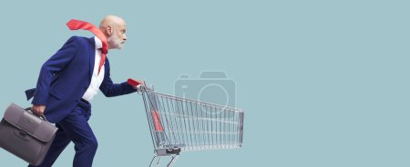 Téléchargez les photos : Homme d'affaires rapide courir et pousser un panier de supermarché - en image libre de droit