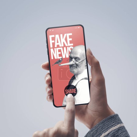 Téléchargez les photos : Partage d'utilisateurs de fausses nouvelles sur le smartphone : un journaliste avec le nez Pinocchio donne des informations trompeuses en ligne - en image libre de droit