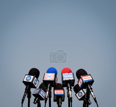 Photo for Microphones prepared for the press conference and mic flags displaying fake news logos: disinformation and propaganda concept, blank copy space - Royalty Free Image