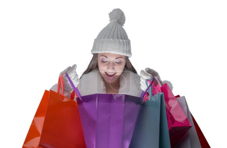 Photo for Happy woman doing Christmas shopping, she is looking inside a bag - Royalty Free Image