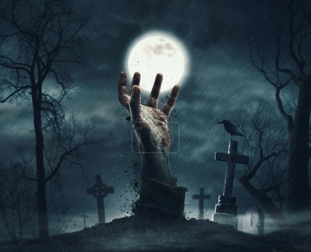 Téléchargez les photos : Zombie se levant de la tombe : main effrayante sortant du sol et vieilles pierres tombales - en image libre de droit