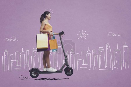 Téléchargez les photos : Femme heureuse tenant des sacs à provisions et chevauchant un e-scooter, ville esquissée en arrière-plan, concept de vente et de shopping - en image libre de droit