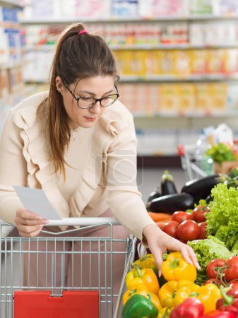 Foto de Mujer haciendo compras en el supermercado, ella está comprando verduras orgánicas frescas en la sección de productos - Imagen libre de derechos