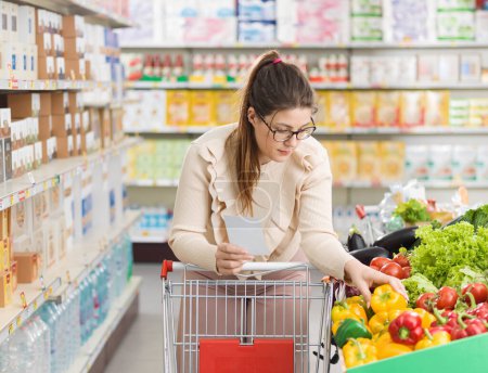 Téléchargez les photos : Femme faisant des courses au supermarché, elle achète des légumes frais biologiques dans la section des produits - en image libre de droit