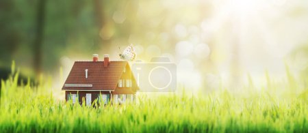 Téléchargez les photos : Jolie maison modèle en plein air dans l'herbe : immobilier et maison écologique, espace de copie - en image libre de droit