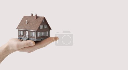 Foto de Hombre sosteniendo una casa modelo: bienes raíces, seguros y concepto de préstamo hipotecario - Imagen libre de derechos