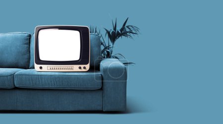 Téléchargez les photos : Vieille télévision rétro avec écran blanc sur le canapé, concept d'appareils de divertissement et vintage - en image libre de droit