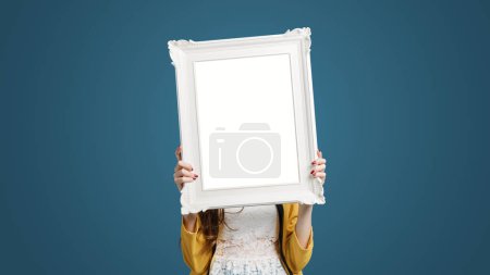 Foto de Hermosa mujer posando y sosteniendo un marco blanco, arte y concepto de decoración - Imagen libre de derechos