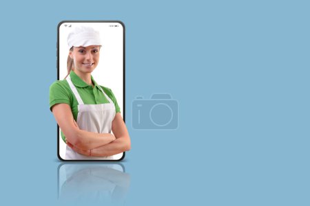 Foto de Clers de supermercado sonrientes profesionales posando en un teléfono inteligente, concepto de compras de comestibles en línea - Imagen libre de derechos