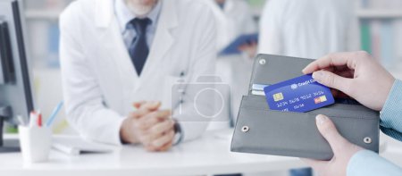 Photo for Woman buying prescription medicines in the pharmacy, she is taking the credit card from the wallet - Royalty Free Image
