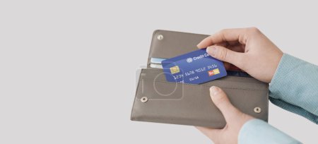 Téléchargez les photos : Femme sortant une carte de crédit de son portefeuille, paiements sans espèces et concept de shopping - en image libre de droit