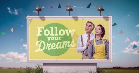 Selbstbewusstes Paar im Vintage-Stil schaut auf Plakatwerbung und Motivationszitat weg: Folgen Sie Ihren Träumen