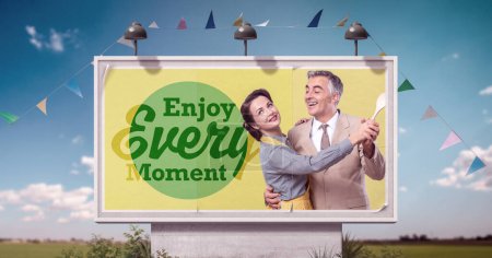 Vintage style couple dancing and inspirational quote on billboard advertisement: enjoy every moment