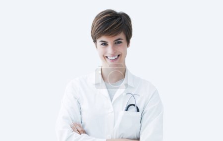 Foto de Doctora confiada posando con los brazos cruzados y sonriendo a la cámara, concepto de salud - Imagen libre de derechos